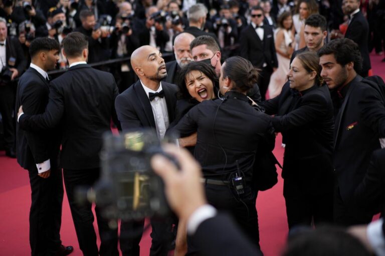 Semi-naked protester painted in Ukraine colours removed from Cannes red carpet